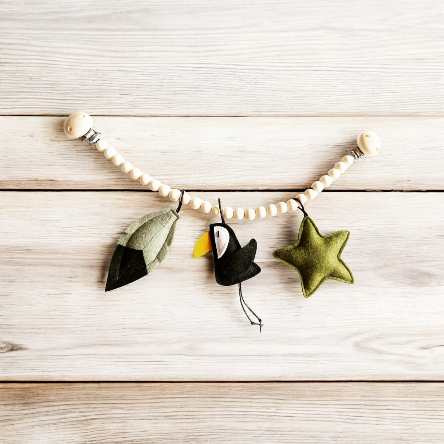 Een stoere wagenspanner van vilt met een toekan en de kleuren oudgroen, legergroen en zwart.